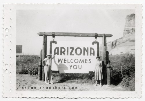 Man and woman pose next to Arizona welcome sign.