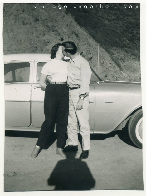 Vintage snapshot of a a couple kissing, with photographer shadow
