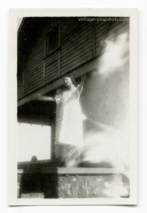 Vintage 1920s snapshot of woman standing with her arms outstretched