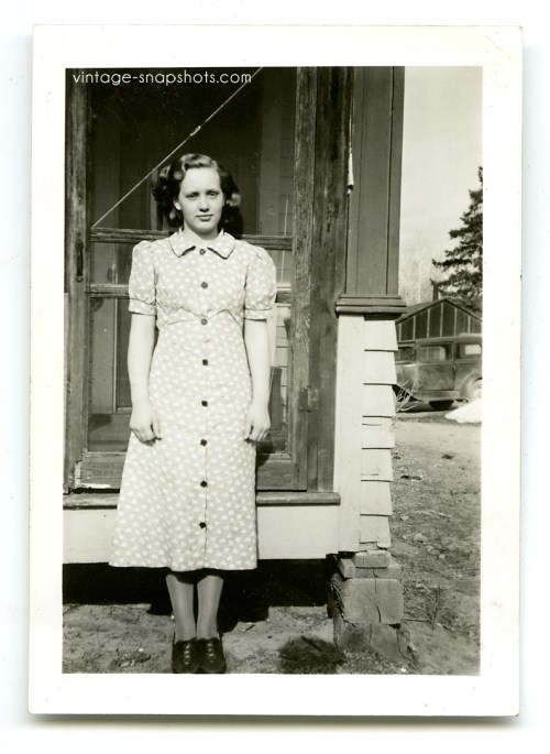Vintage 1930s snapshot of girl in front of screen door