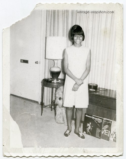 1960s snapshot of cute Black girl posing with record albums and singles