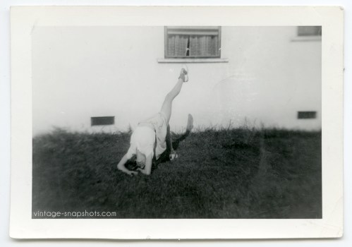 Oddball snapshot of woman posing upside down on grass in dance move, circa 1940s Los Angeles.